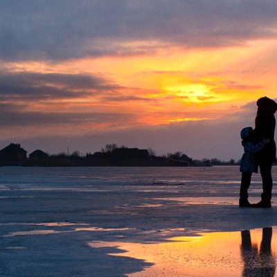 adult and child hugging on beach